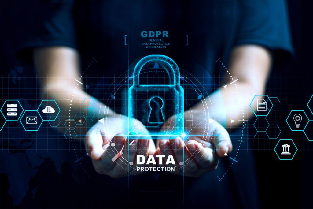  A person is holding a glowing blue padlock in the palm of their hand with several icons around them including an envelope, two buildings, a clock, a light bulb, and a document. The padlock has the words 'GDPR - General Data Protection Regulation' and 'Data Protection' written on it.